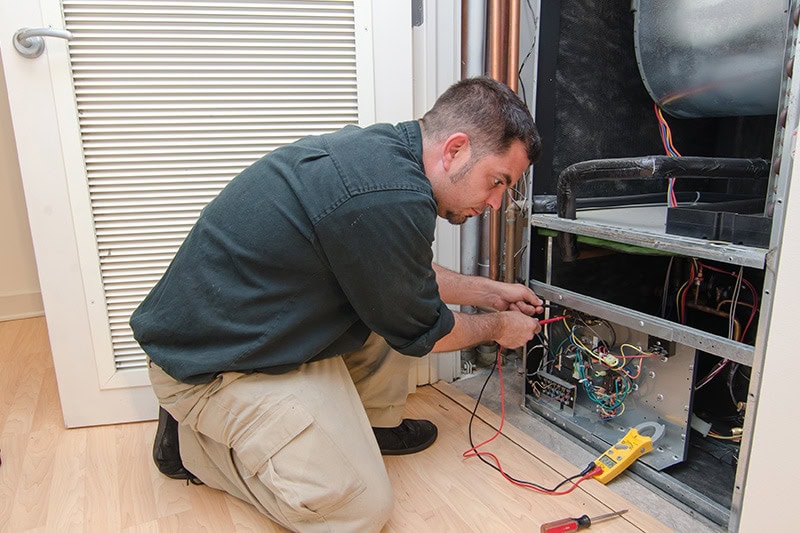 HVAC technician working on a residential heat pump, HVAC Maintenance Checklist for Homeowners | Port Orchard, WA | Dana's