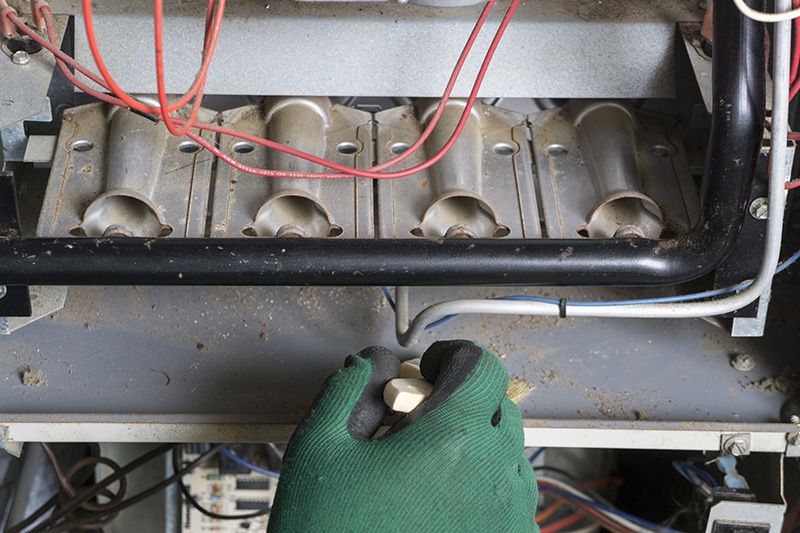 Image of someone working on a furnace. What Are Signs I Need a New Furnace?